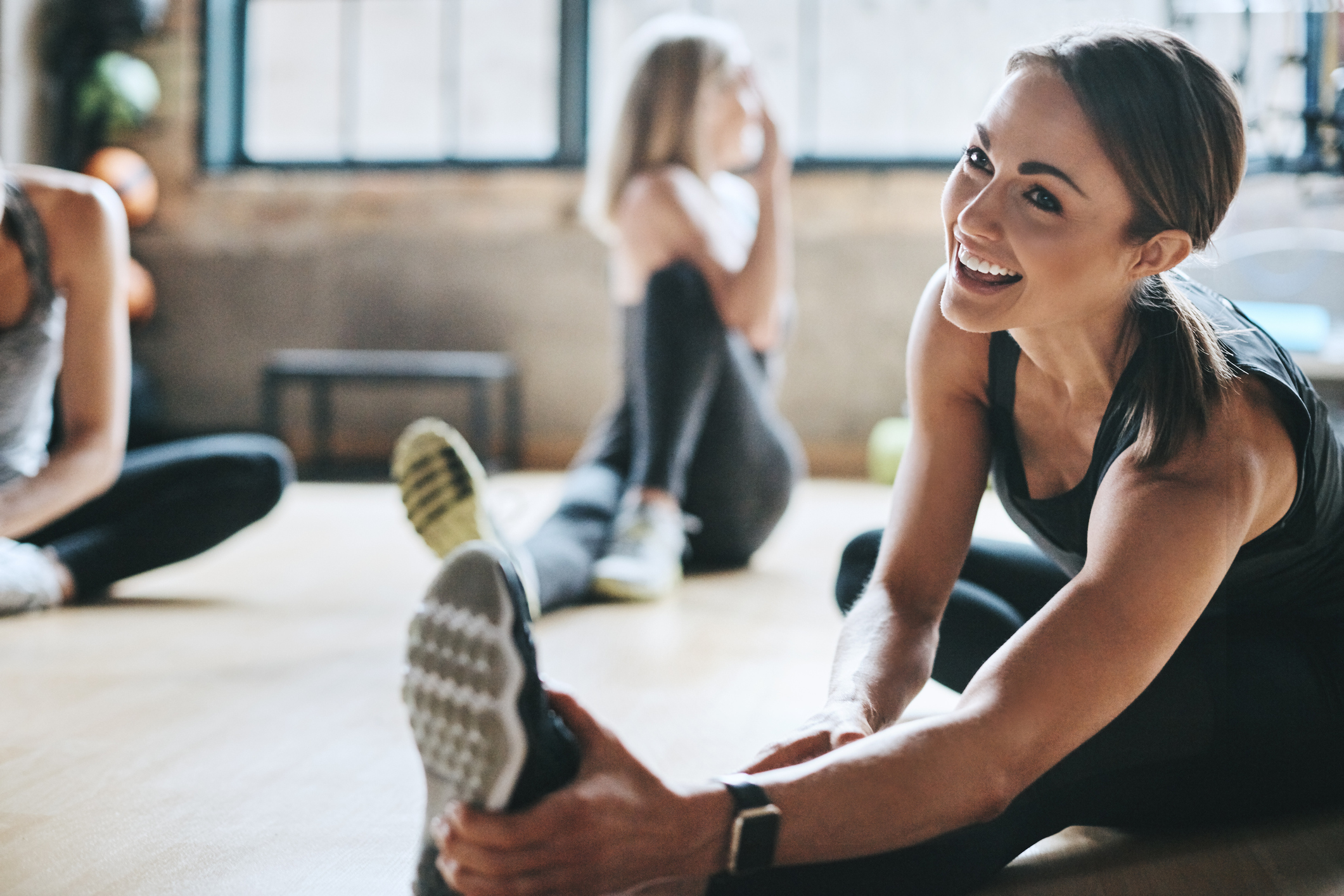 Shot of mature women stretching with a young female instructor during a training class at the gym